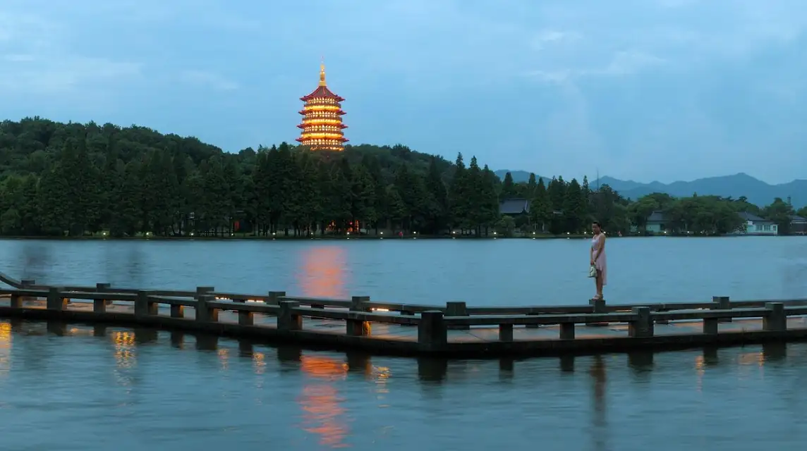 West Lake in Hangzhou with a lit pagoda at dusk