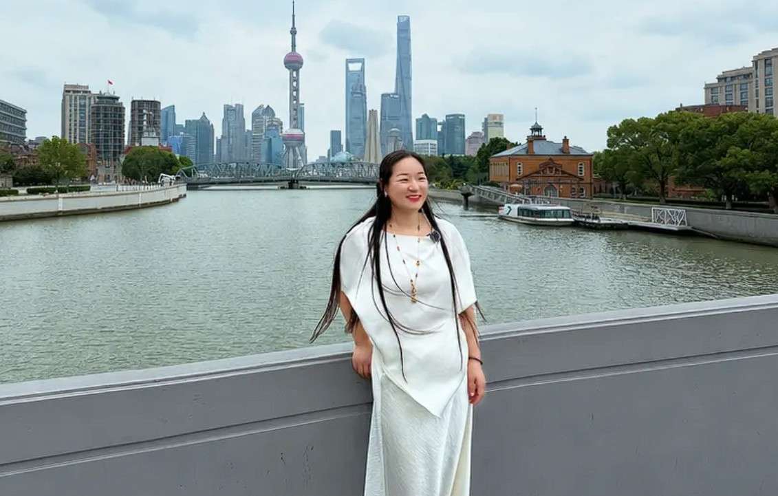 July, a local tour guide, with the Shanghai skyline